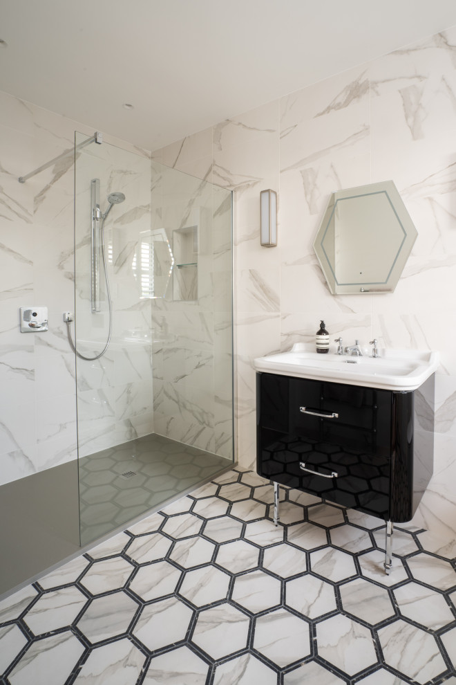Inredning av ett skandinaviskt badrum, med en öppen dusch, vit kakel, porslinskakel, vita väggar, klinkergolv i porslin, ett väggmonterat handfat, svart golv och med dusch som är öppen
