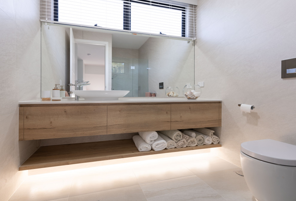 Esempio di una stanza da bagno minimal di medie dimensioni con ante lisce, ante in legno scuro, piastrelle grigie, lavabo a bacinella, pavimento grigio e top bianco