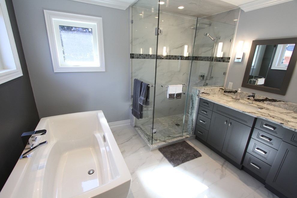 Medium sized classic ensuite bathroom in Toronto with recessed-panel cabinets, grey cabinets, a freestanding bath, a corner shower, a two-piece toilet, white tiles, porcelain tiles, grey walls, porcelain flooring, a submerged sink and quartz worktops.