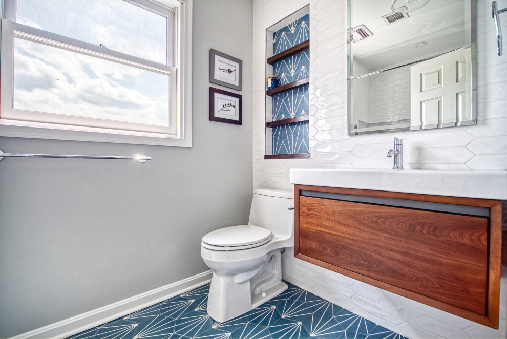 Пример оригинального дизайна: ванная комната среднего размера в современном стиле с плоскими фасадами, фасадами цвета дерева среднего тона, накладной ванной, душем над ванной, унитазом-моноблоком, белой плиткой, керамической плиткой, серыми стенами, полом из керамической плитки, душевой кабиной, монолитной раковиной, столешницей из искусственного камня, синим полом, шторкой для ванной и белой столешницей
