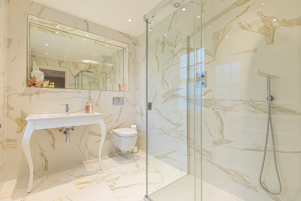 Modern inredning av ett mellanstort vit vitt badrum med dusch, med vita skåp, en hörndusch, en vägghängd toalettstol, beige kakel, porslinskakel, klinkergolv i porslin, ett undermonterad handfat, beiget golv och dusch med gångjärnsdörr