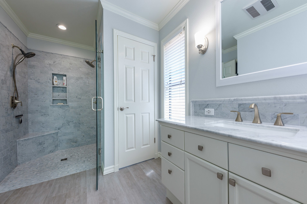 Example of a mid-sized trendy master white tile and marble tile light wood floor and gray floor bathroom design in Other with flat-panel cabinets, white cabinets, a one-piece toilet, white walls, an undermount sink, marble countertops, a hinged shower door and white countertops