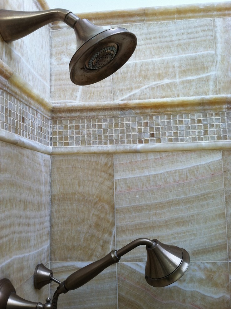 Medelhavsstil inredning av ett stort en-suite badrum, med ett undermonterad handfat, luckor med upphöjd panel, vita skåp, ett hörnbadkar, en hörndusch, en toalettstol med separat cisternkåpa, gul kakel, stenkakel, vita väggar och kalkstensgolv