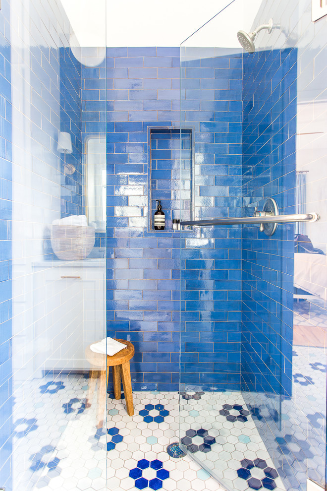 Doorless shower - mid-sized modern 3/4 blue tile and ceramic tile ceramic tile and white floor doorless shower idea in Minneapolis with recessed-panel cabinets, white cabinets, white walls, a drop-in sink, marble countertops and white countertops