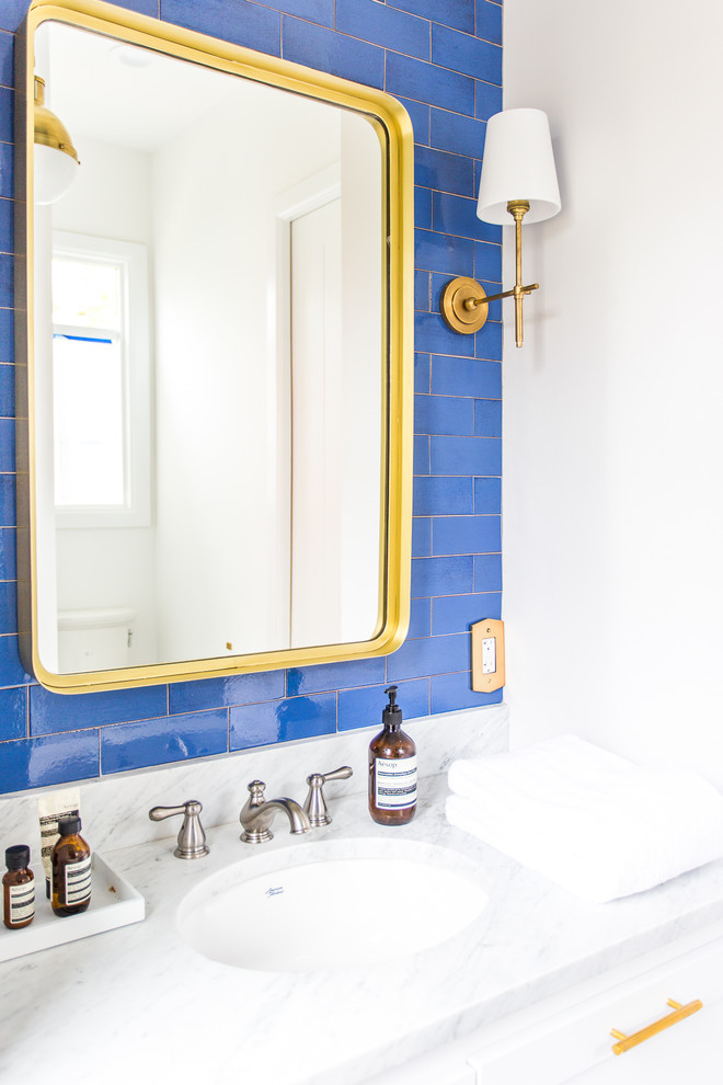 Пример оригинального дизайна: ванная комната среднего размера в стиле модернизм с фасадами с утопленной филенкой, белыми фасадами, открытым душем, синей плиткой, керамической плиткой, белыми стенами, полом из керамической плитки, душевой кабиной, накладной раковиной, мраморной столешницей, белым полом и белой столешницей