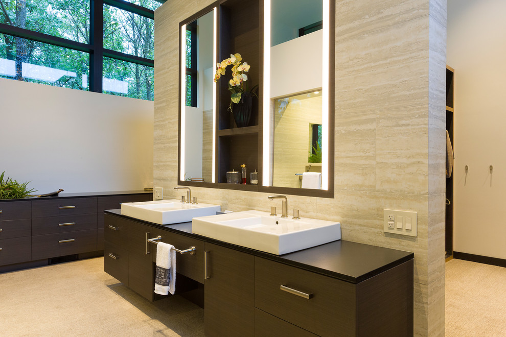Expansive contemporary ensuite wet room bathroom in Other with flat-panel cabinets, dark wood cabinets, a one-piece toilet, beige tiles, travertine tiles, white walls, porcelain flooring, a vessel sink, granite worktops, beige floors, a hinged door and black worktops.