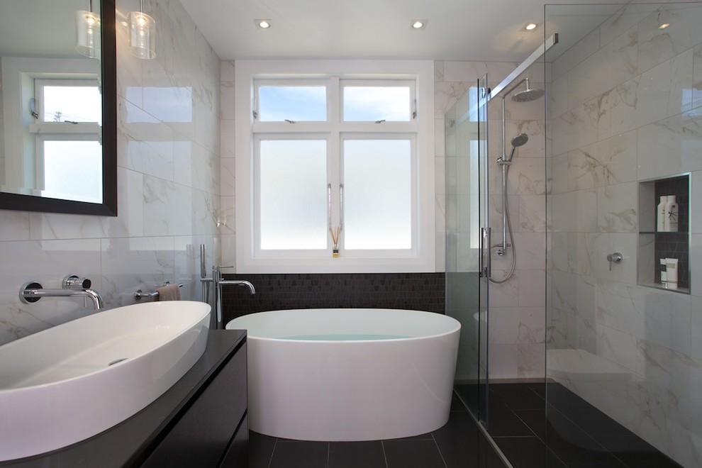 Medium sized modern bathroom in Auckland with a vessel sink, freestanding cabinets, black cabinets, engineered stone worktops, a freestanding bath, a built-in shower, black tiles, porcelain tiles, white walls, porcelain flooring and a one-piece toilet.
