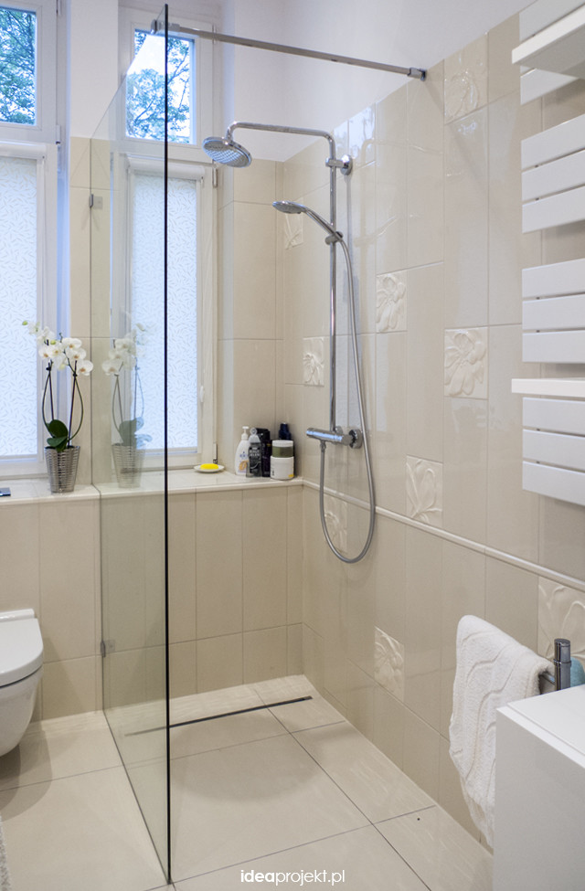 Inredning av ett eklektiskt litet en-suite badrum, med ett väggmonterat handfat, släta luckor, beige skåp, laminatbänkskiva, en öppen dusch, en vägghängd toalettstol, beige kakel, keramikplattor, beige väggar och klinkergolv i keramik