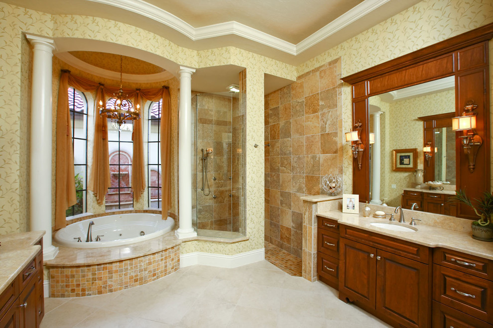 Cette photo montre une grande salle de bain principale méditerranéenne en bois foncé avec un lavabo posé, un placard avec porte à panneau surélevé, un plan de toilette en quartz modifié, un bain bouillonnant, une douche d'angle, un mur jaune, un sol en carrelage de porcelaine et un carrelage marron.