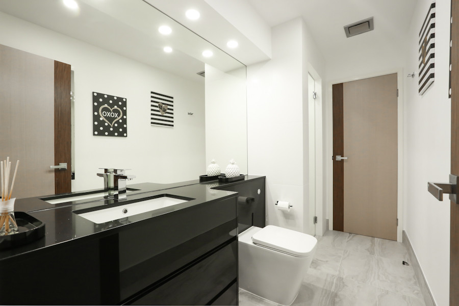На фото: ванная комната среднего размера в стиле модернизм с черными фасадами, белыми стенами, душевой кабиной, серым полом, плоскими фасадами, душевой комнатой, инсталляцией, белой плиткой, керамогранитной плиткой, полом из керамической плитки, врезной раковиной, столешницей из искусственного кварца и душем с распашными дверями