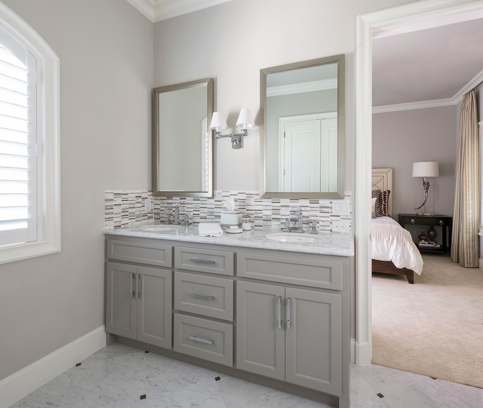 Réalisation d'une salle de bain tradition de taille moyenne avec un placard à porte shaker, des portes de placard grises, WC à poser, un carrelage gris, un mur gris, un sol en marbre, un lavabo encastré, un plan de toilette en marbre et un sol blanc.