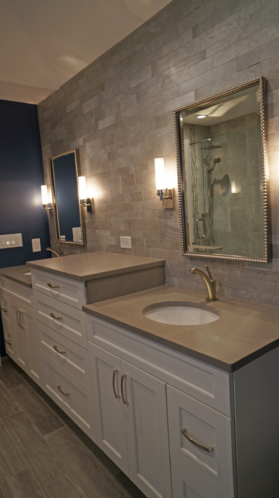 Medium sized classic ensuite bathroom in Philadelphia with recessed-panel cabinets, white cabinets, a two-piece toilet, grey tiles, porcelain tiles, grey walls, porcelain flooring, a submerged sink, engineered stone worktops, a freestanding bath and an alcove shower.