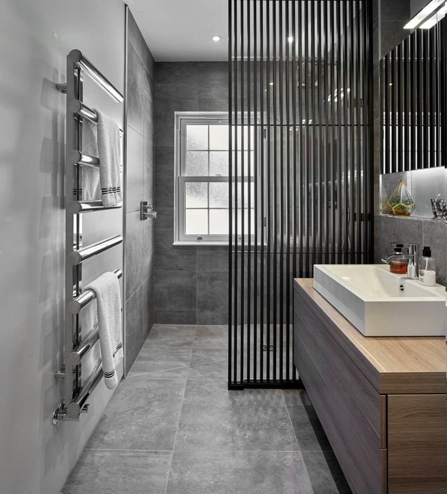 Medium sized contemporary shower room bathroom in Other with flat-panel cabinets, light wood cabinets, a walk-in shower, a wall mounted toilet, grey tiles, porcelain tiles, grey walls, porcelain flooring, grey floors and an open shower.