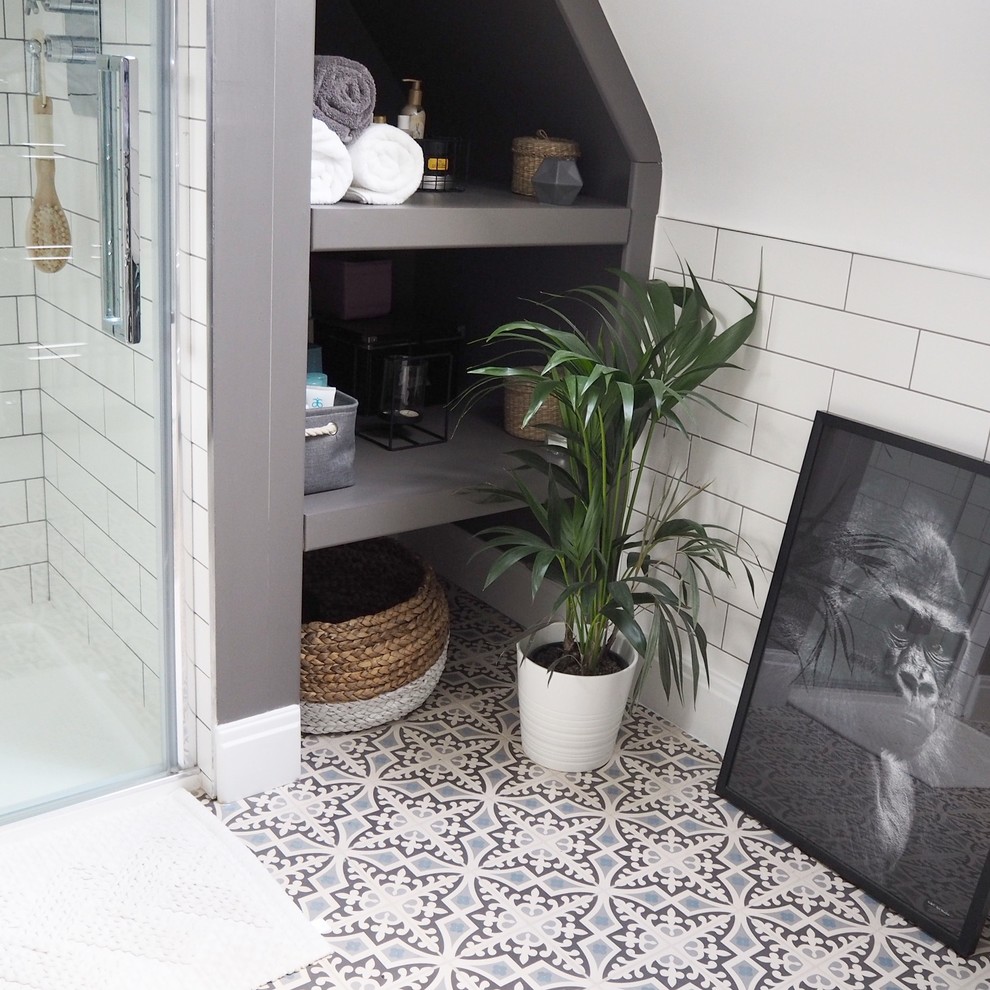 Small scandinavian ensuite bathroom in Other with shaker cabinets, blue cabinets, an alcove shower, a wall mounted toilet, white tiles, ceramic tiles, grey walls, ceramic flooring, engineered stone worktops, grey floors, a hinged door and white worktops.