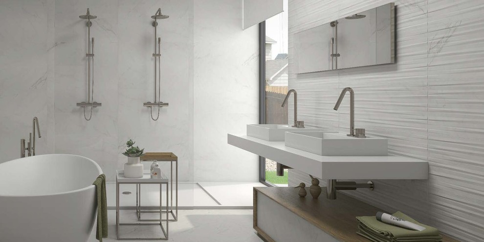 Design ideas for a medium sized contemporary family bathroom in Essex with recessed-panel cabinets, light wood cabinets, a freestanding bath, a built-in shower, white tiles, a trough sink and solid surface worktops.