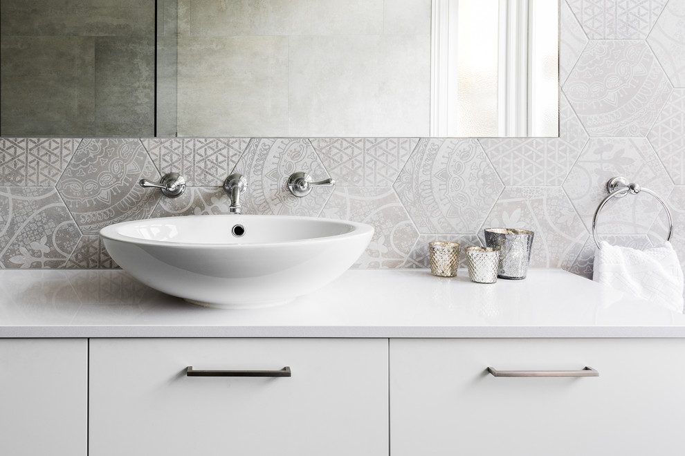 Foto de cuarto de baño principal contemporáneo de tamaño medio con armarios con paneles lisos, puertas de armario blancas, bañera con patas, ducha abierta, sanitario de una pieza, baldosas y/o azulejos grises, baldosas y/o azulejos de cerámica, paredes grises, suelo de baldosas de cerámica, lavabo sobreencimera, encimera de cuarzo compacto, suelo gris y ducha con puerta con bisagras