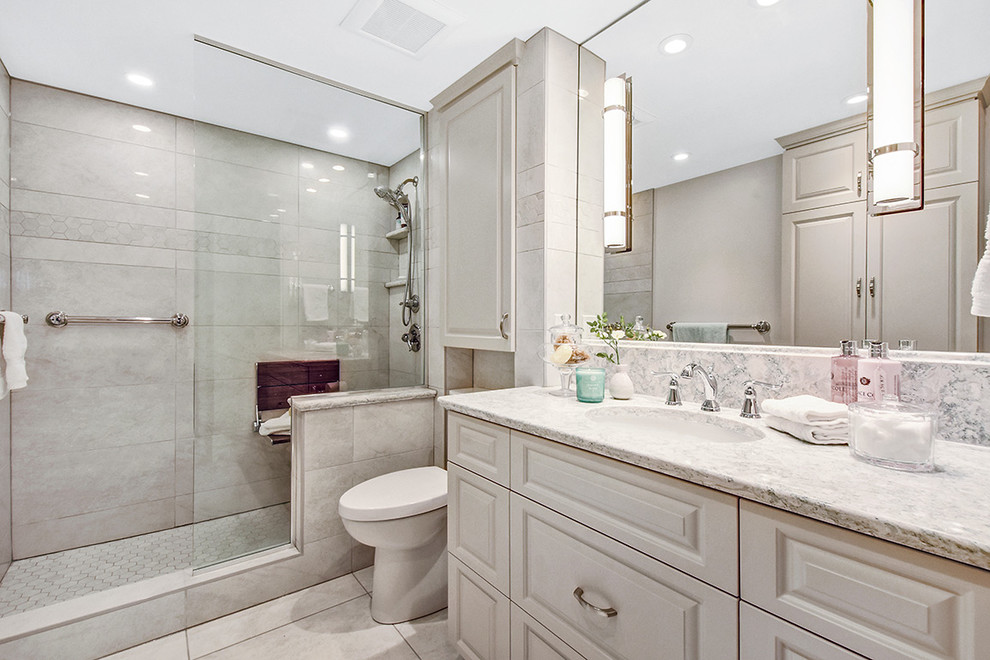 Mid-sized transitional master beige tile and porcelain tile porcelain tile and beige floor bathroom photo in Ottawa with raised-panel cabinets, beige cabinets, a one-piece toilet, beige walls, an undermount sink, quartz countertops and multicolored countertops