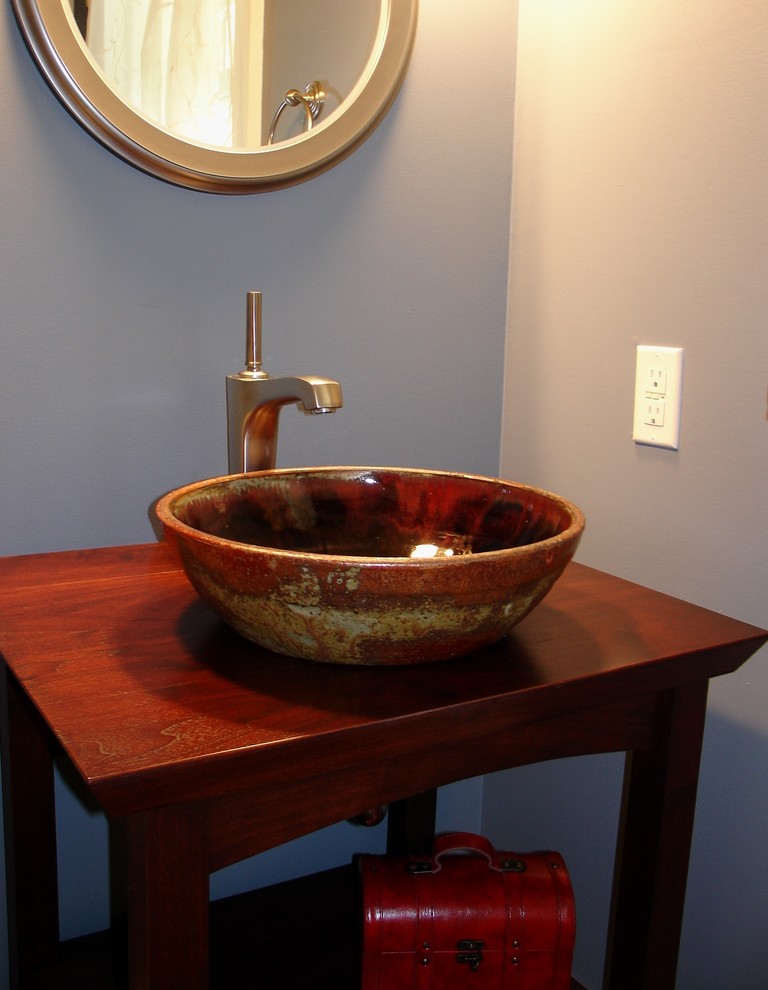 Small traditional bathroom in Milwaukee with open cabinets, dark wood cabinets, a two-piece toilet, blue walls, a vessel sink and wooden worktops.
