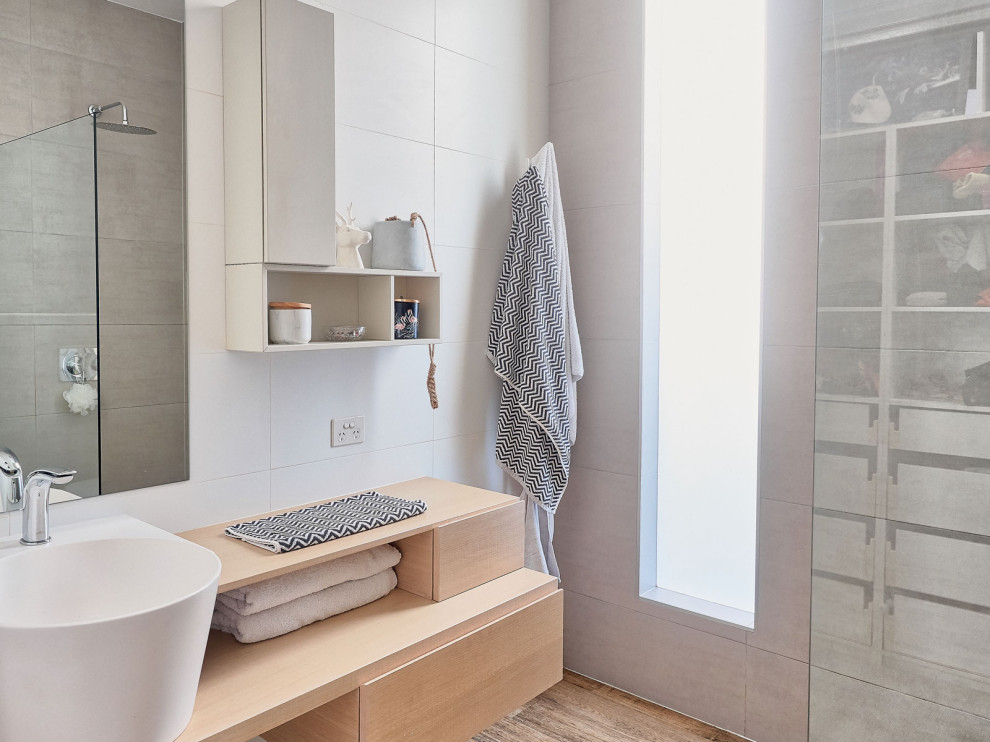 Design ideas for a medium sized scandinavian bathroom in Melbourne with freestanding cabinets, light wood cabinets, a freestanding bath, a corner shower, black tiles, grey walls, grey floors, an open shower, grey worktops, a single sink and a built in vanity unit.