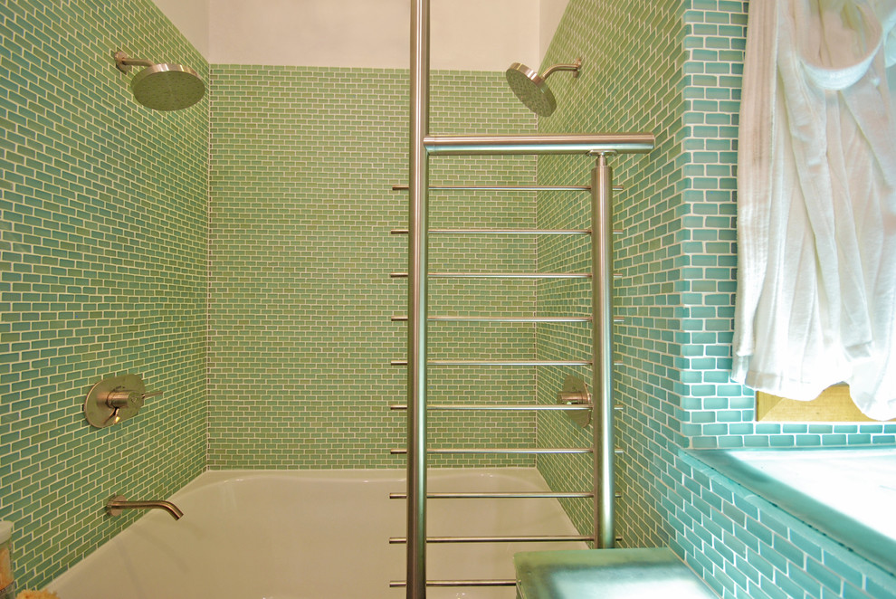 Стильный дизайн: главная ванная комната среднего размера в стиле модернизм с раковиной с несколькими смесителями, плоскими фасадами, столешницей из талькохлорита, ванной в нише, двойным душем, унитазом-моноблоком, зеленой плиткой, стеклянной плиткой, полом из керамогранита, зелеными стенами, зеленым полом и открытым душем - последний тренд