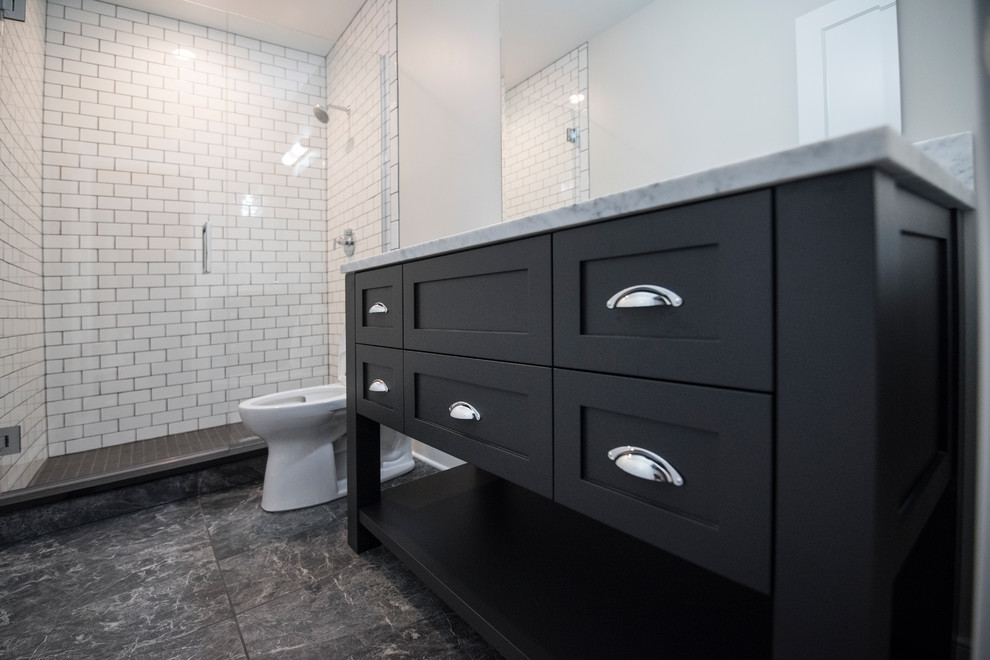 Photo of a medium sized contemporary ensuite bathroom in Chicago with shaker cabinets, black cabinets, an alcove shower, white tiles, metro tiles, white walls, a submerged sink, marble worktops, grey floors and a hinged door.