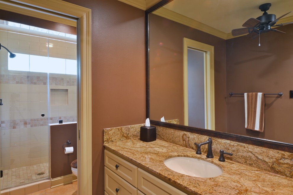 Inspiration for a mid-sized timeless kids' beige tile and ceramic tile ceramic tile alcove shower remodel in Houston with an undermount sink, recessed-panel cabinets, beige cabinets, granite countertops, a two-piece toilet and brown walls