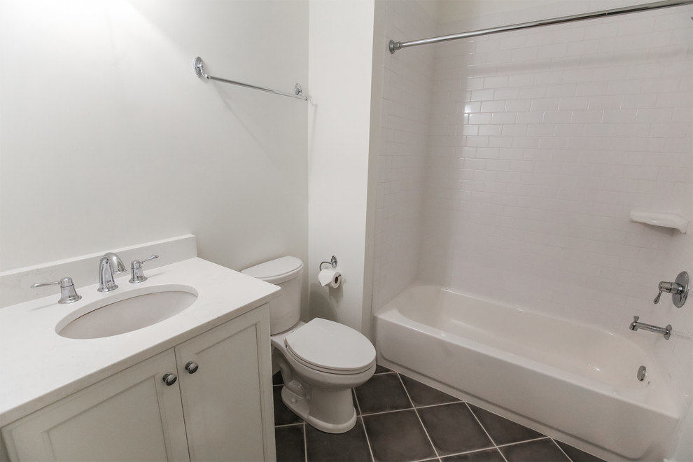 Cette photo montre une salle de bain chic avec une baignoire posée, un combiné douche/baignoire, un carrelage blanc, un carrelage métro, un mur blanc, un sol en carrelage de porcelaine et un sol gris.