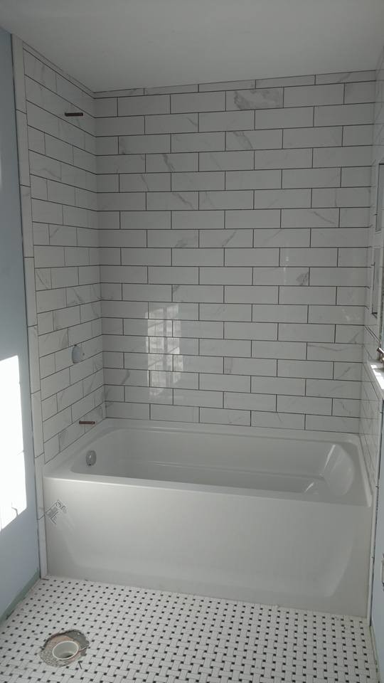 Cette image montre une petite salle d'eau traditionnelle avec une baignoire en alcôve, un combiné douche/baignoire, un carrelage gris, un carrelage blanc, un carrelage métro, un mur bleu et un sol en linoléum.