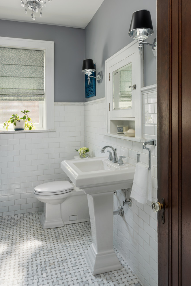 Amerikansk inredning av ett mellanstort badrum, med vita skåp, en kantlös dusch, en toalettstol med separat cisternkåpa, vit kakel, keramikplattor, grå väggar, marmorgolv, ett piedestal handfat, grått golv och med dusch som är öppen
