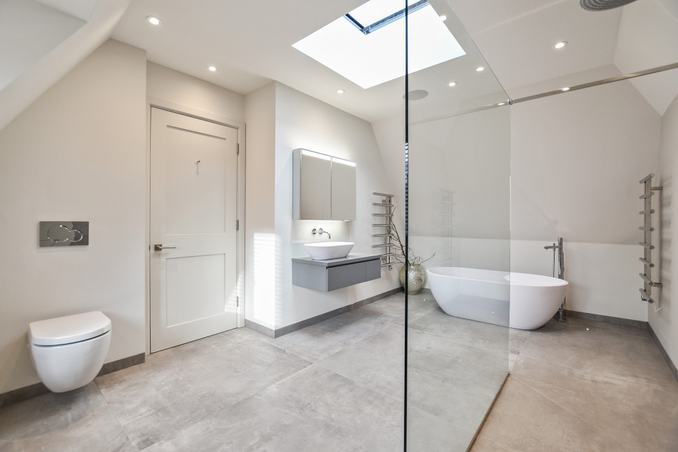 Foto de cuarto de baño principal y flotante actual grande con armarios con paneles lisos, bañera exenta, ducha abierta y sanitario de pared