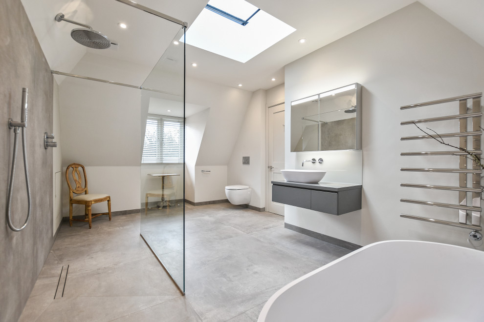 Foto på ett stort funkis en-suite badrum, med släta luckor, ett fristående badkar, en öppen dusch och en vägghängd toalettstol