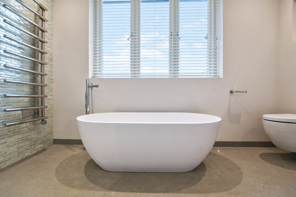 Diseño de cuarto de baño principal y flotante contemporáneo grande con armarios con paneles lisos, bañera exenta, ducha abierta y sanitario de pared