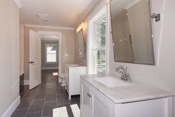Cette photo montre une grande salle de bain tendance pour enfant avec un placard à porte shaker, des portes de placard blanches, une baignoire posée, un combiné douche/baignoire, WC à poser, un carrelage blanc, des carreaux de céramique, un mur beige, un sol en carrelage de céramique, un lavabo encastré, un plan de toilette en marbre, un sol gris et une cabine de douche avec un rideau.