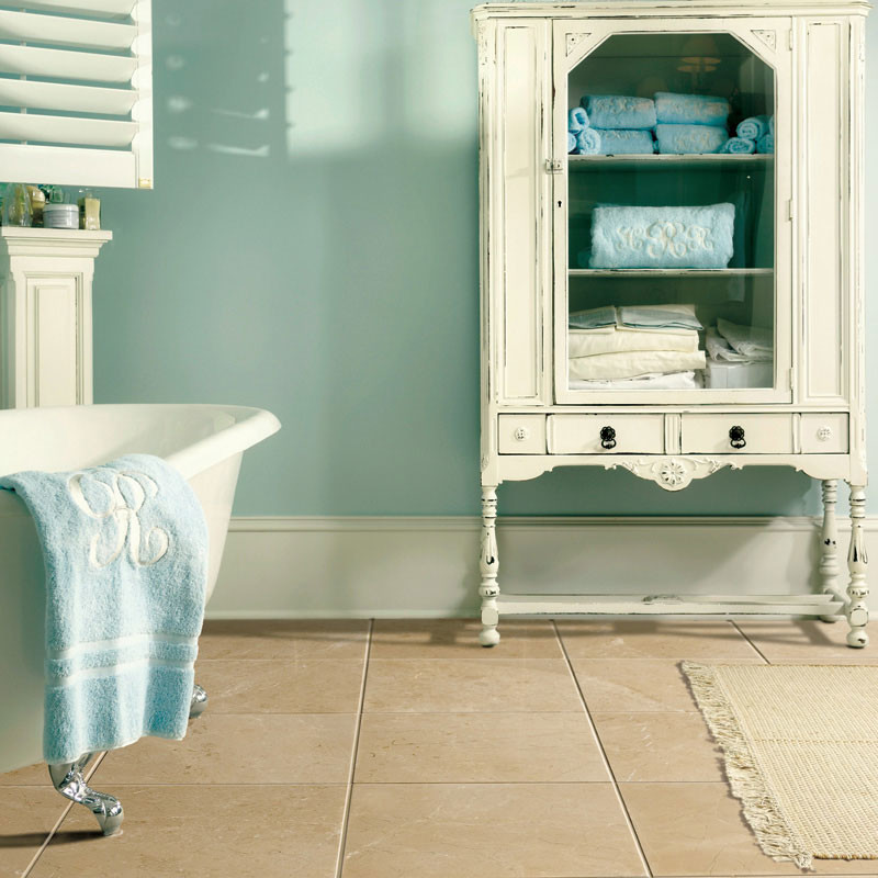 Réalisation d'une salle de bain principale victorienne en bois vieilli de taille moyenne avec un placard sans porte, une baignoire sur pieds, un mur bleu, un sol en marbre et un sol beige.