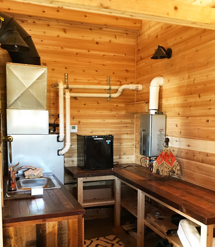 Foto de sauna rústica con armarios abiertos y encimera de madera