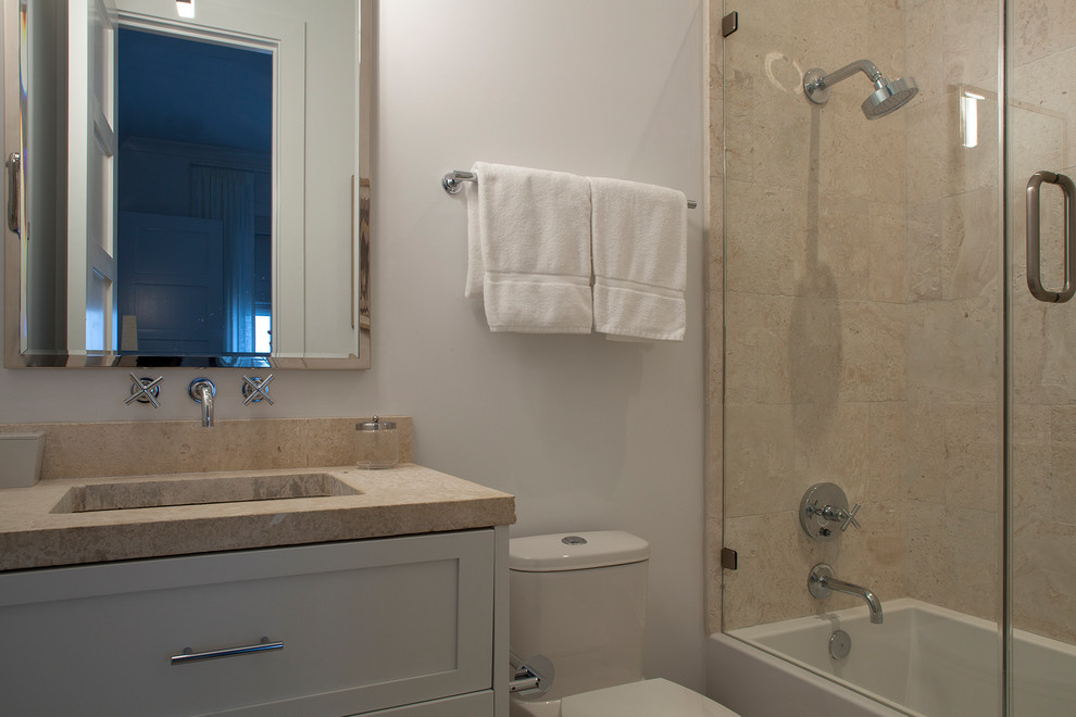Пример оригинального дизайна: ванная комната среднего размера в классическом стиле с фасадами в стиле шейкер, белыми фасадами, ванной в нише, душем в нише, унитазом-моноблоком, бежевой плиткой, плиткой из травертина, белыми стенами, душевой кабиной, врезной раковиной, столешницей из бетона и душем с распашными дверями