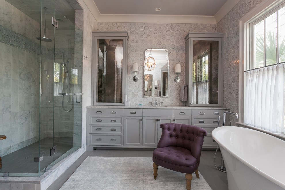 Inredning av ett klassiskt stort grå grått en-suite badrum, med släta luckor, grå skåp, ett badkar med tassar, grå väggar, ett undermonterad handfat, marmorbänkskiva, grått golv och dusch med gångjärnsdörr
