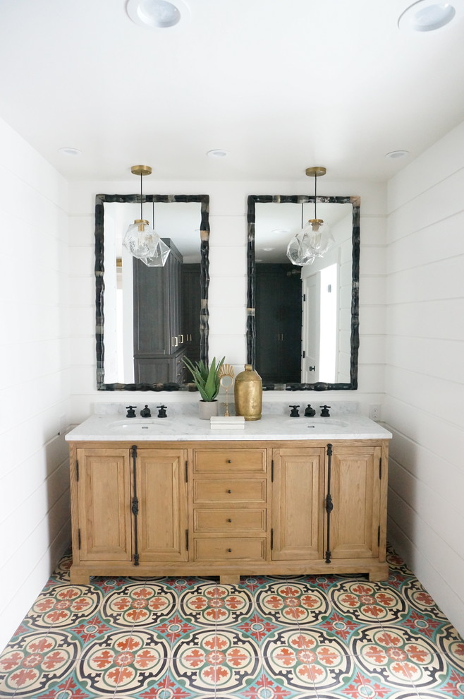 オレンジカウンティにある地中海スタイルのおしゃれな浴室 (淡色木目調キャビネット、白い壁、アンダーカウンター洗面器、レイズドパネル扉のキャビネット) の写真