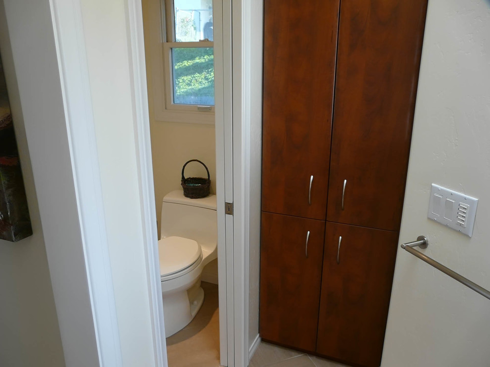 Photo of a large modern ensuite bathroom in San Diego with flat-panel cabinets, dark wood cabinets, an alcove shower, a one-piece toilet, white walls, porcelain flooring and a vessel sink.