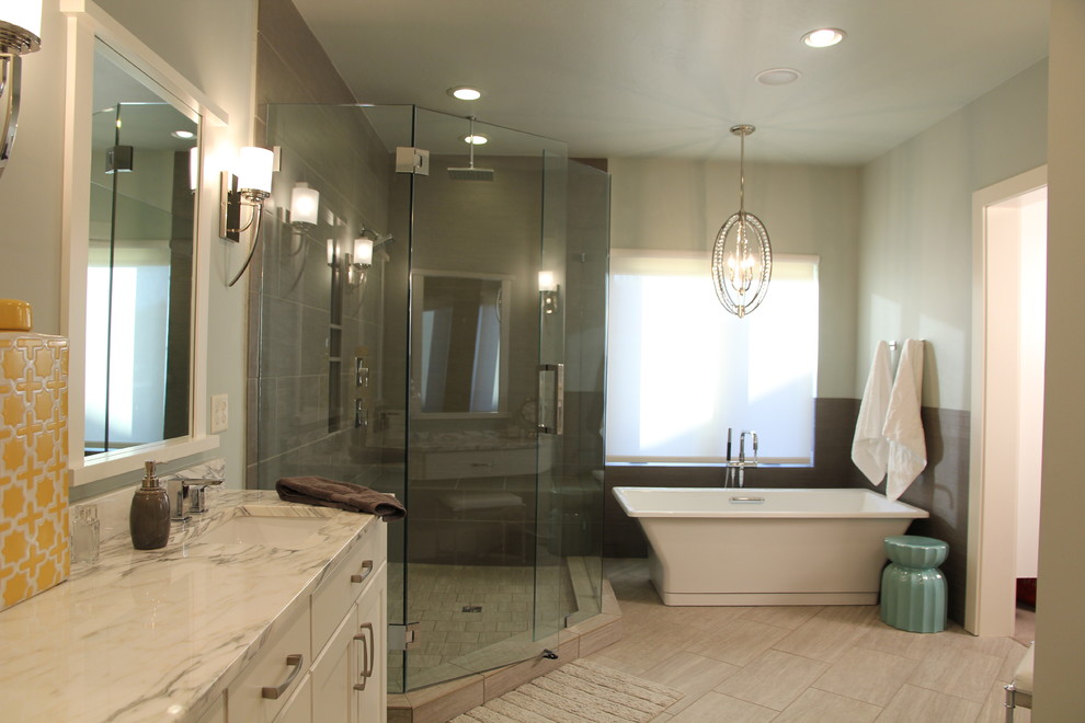 Inredning av ett klassiskt stort en-suite badrum, med skåp i shakerstil, vita skåp, ett fristående badkar, en hörndusch, beige kakel, porslinskakel, grå väggar, klinkergolv i porslin, ett undermonterad handfat och marmorbänkskiva