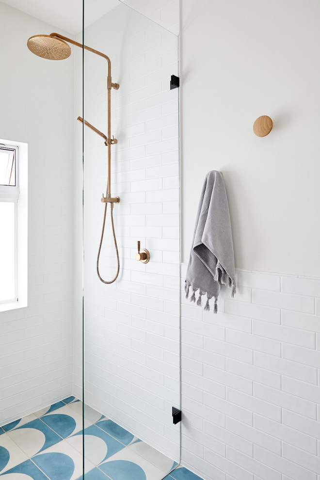 Inspiration för maritima badrum, med en vägghängd toalettstol, vit kakel, tunnelbanekakel, vita väggar, cementgolv, blått golv, en kantlös dusch och med dusch som är öppen