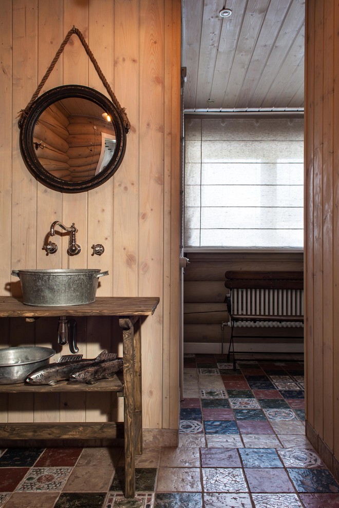 Modelo de cuarto de baño de estilo de casa de campo con lavabo sobreencimera, armarios abiertos, puertas de armario de madera en tonos medios y suelo multicolor