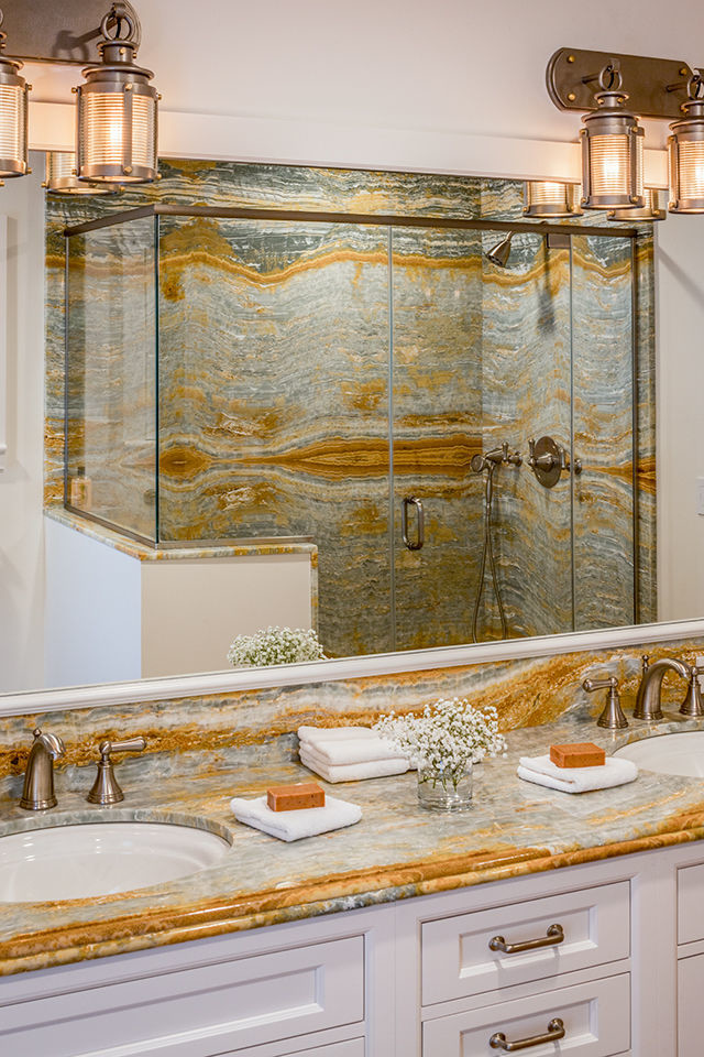 Example of a transitional master multicolored tile and marble tile corner shower design in Boston with beaded inset cabinets, white cabinets, white walls, an undermount sink, marble countertops, a hinged shower door and multicolored countertops