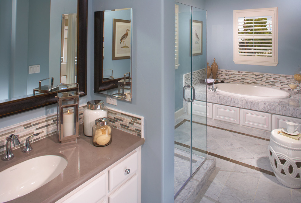 Diseño de cuarto de baño principal clásico renovado grande con armarios estilo shaker, puertas de armario blancas, bañera encastrada, ducha empotrada, baldosas y/o azulejos beige, paredes azules y lavabo bajoencimera