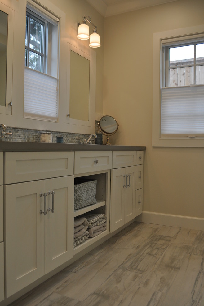 Exempel på ett mellanstort modernt en-suite badrum, med luckor med infälld panel, vita skåp, en dusch i en alkov, blå kakel, grå kakel, vita väggar, mellanmörkt trägolv, ett undermonterad handfat, bänkskiva i akrylsten och stickkakel