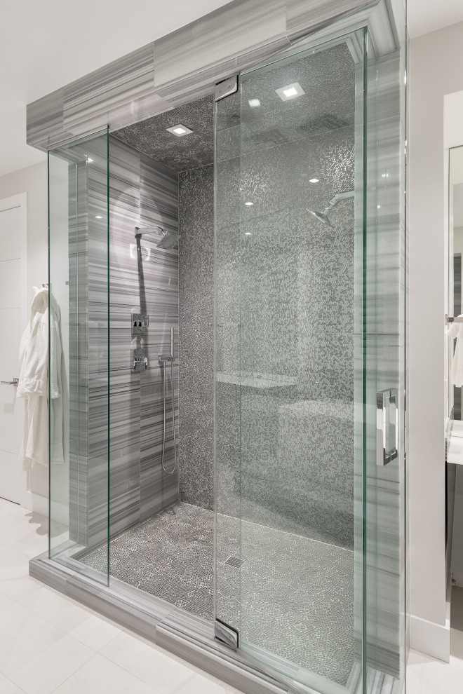 Cette image montre une douche en alcôve principale minimaliste de taille moyenne avec un carrelage gris, une plaque de galets, un mur gris, un sol en galet, un sol gris et une cabine de douche à porte battante.