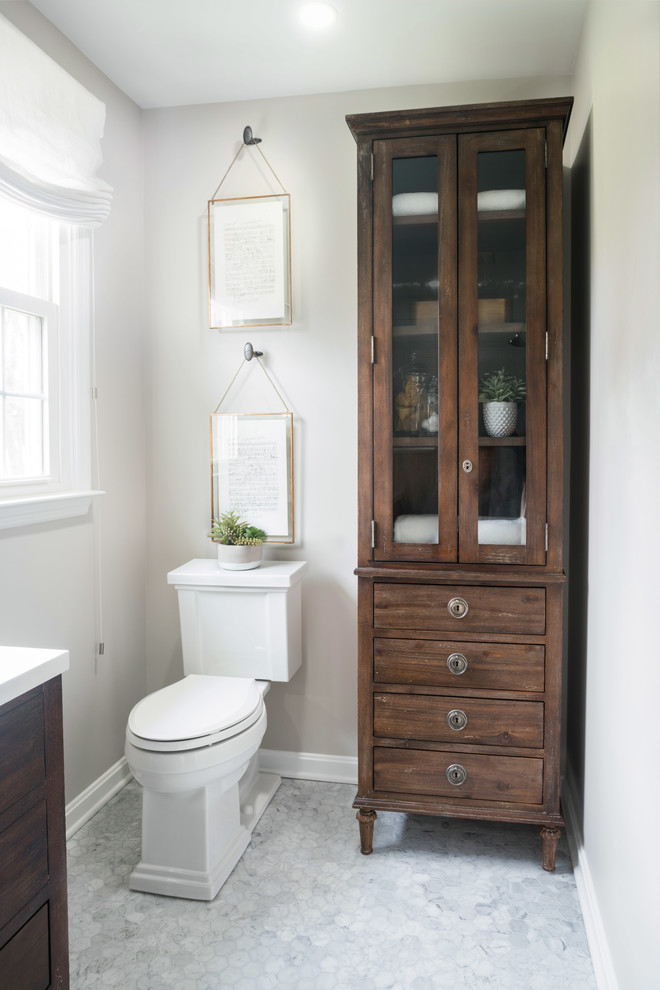 Klassisk inredning av ett litet en-suite badrum, med möbel-liknande, skåp i mörkt trä, en dusch i en alkov, en toalettstol med hel cisternkåpa, vit kakel, porslinskakel, marmorgolv, ett konsol handfat, bänkskiva i kvarts och dusch med gångjärnsdörr