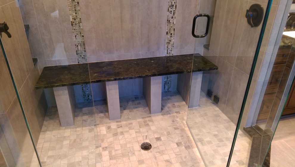 Photo of a medium sized classic ensuite bathroom in Denver with recessed-panel cabinets, medium wood cabinets, a submerged bath, a shower/bath combination, a one-piece toilet, green tiles, stone slabs, beige walls, ceramic flooring, a submerged sink, granite worktops, grey floors and a hinged door.