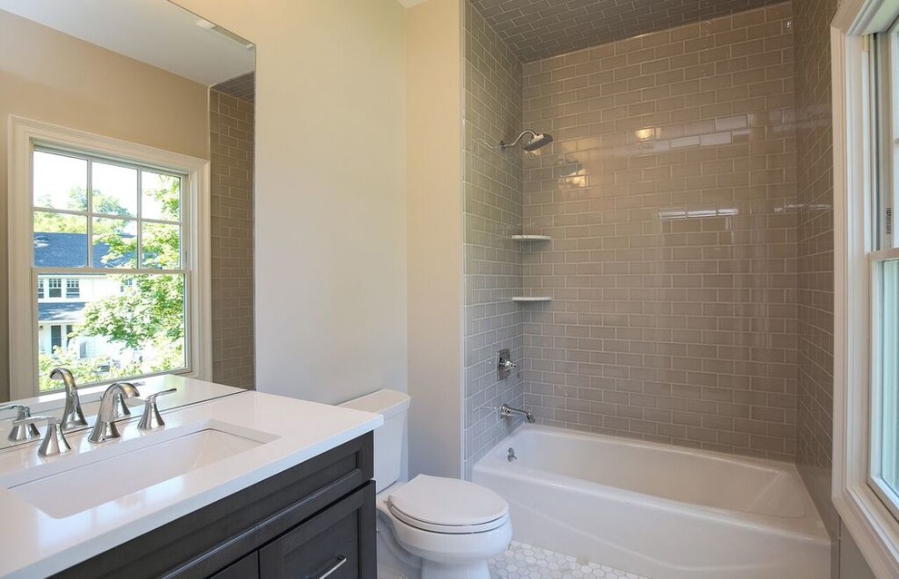 Example of a mid-sized transitional gray tile and porcelain tile ceramic tile bathroom design in New York with shaker cabinets, black cabinets, a two-piece toilet, beige walls, an undermount sink and quartzite countertops