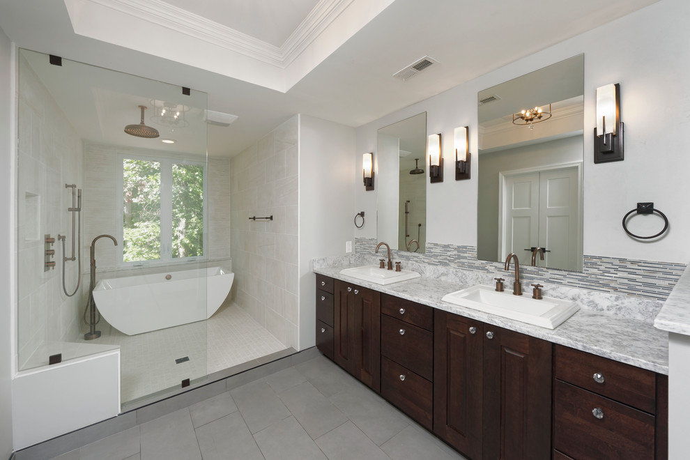Inspiration for a large craftsman master gray tile and ceramic tile ceramic tile and gray floor bathroom remodel in DC Metro with a drop-in sink, raised-panel cabinets, dark wood cabinets, quartz countertops, a two-piece toilet and gray walls